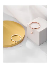 Detail of 925 silver and rose gold rings featuring a delicate chain and bead pendant