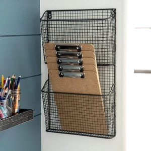 Side view of wall-mounted black wire mesh organizer holding wooden clipboards on the wall