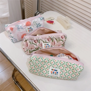 Detailed view of three floral cotton pouches with zippers and BEST woven labels