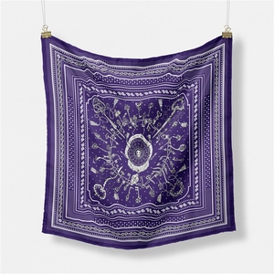 Macro detail of silk square scarf featuring retro key motifs and ornate patterns