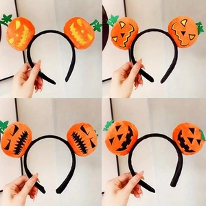 Detailed view of four different plush pumpkin headbands with funny facial expressions