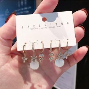 Detail of 6-piece gold earring set with white zircons and silver posts on display card