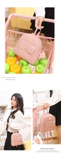 Detail of pink faux leather mini backpack with embossed heart patterns and gold hardware