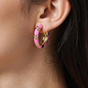 Nahaufnahme der rosa Emaille-Ohrringe mit Zirkonia, getragen von einem Modell