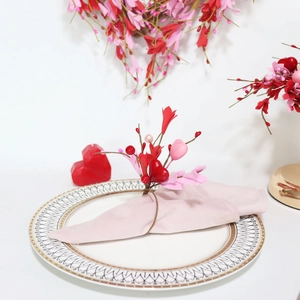 Detail of red and pink heart napkin ring with berries on a textured plate for table decor