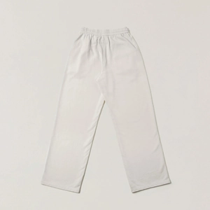 Dettaglio dell'elastico in vita e del logo Essentials in rilievo sui pantaloni sportivi