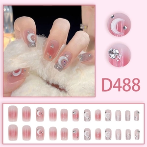 Detail of pink gradient press-on nails with moon accents and sparkling rhinestones