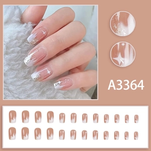 Press-on nails in creamy white and champagne gold gradient with sparkling star designs