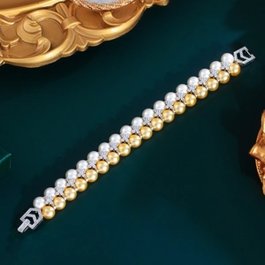 Elegant double-row pearl bracelet with white and gold pearls and zircon-encrusted silver clasp