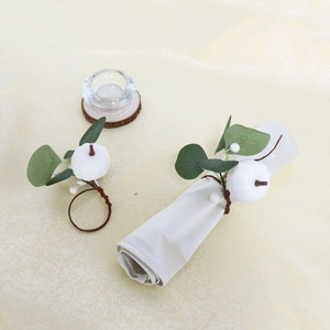 Detail view of white pumpkin napkin ring with faux eucalyptus leaves and berries