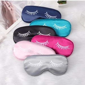 Detailed flat lay of six colorful satin eye masks with eyelash print on plush background