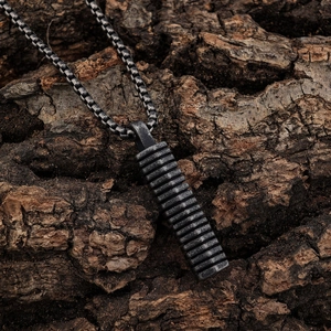 Vintage Viking style stainless steel pendant with textured bar on a natural wood background