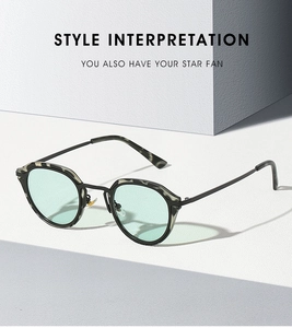 Detail of oval sunglasses with mint green lenses and marble pattern acetate frames