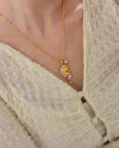 Detail of 18k gold plated unicorn necklace with pink and white cubic zirconia stones