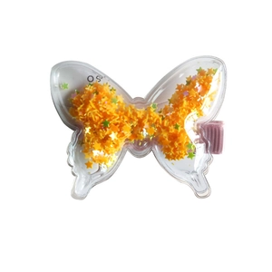Dettaglio macro della clip a farfalla con paillettes a stella e fermaglio in tessuto