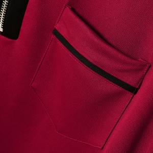 Detail aus Piqué-Strick mit Reißverschluss und schwarzem Besatz auf dunkelrotem Polo
