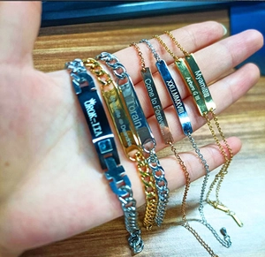 Close-up of hand holding multiple braided PU leather bracelets with engraved stainless steel bars