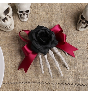 Detailed view of Halloween hair clip with black rose, red bow, and skeleton hand