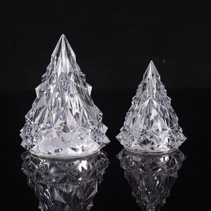 Close-up of two crystal iceberg Christmas tree night lights on a reflective black surface