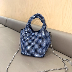 Detail of navy blue rhinestone handbag with silver metal chain on a leather seat