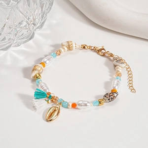 Detail of beach style beaded bracelet with pearl, seashell charm, and colorful accents