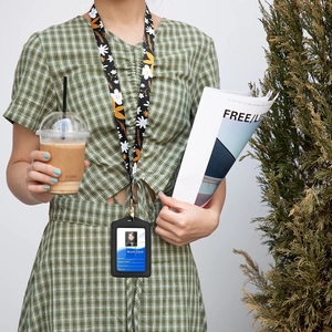 Floral print polyester lanyard with black leather ID badge holder shown in a lifestyle setting