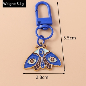 Blue enamel moth keychain with evil eye pattern detailing size and weight dimensions