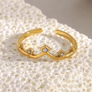 Macro detail of 18K gold plated crown ring with three sparkling small crystals