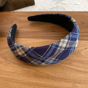 Detail of blue and grey checkered fabric texture on a wide-brimmed padded headband