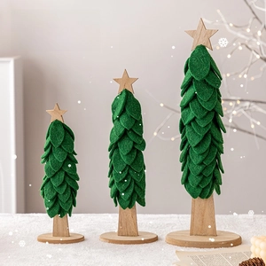 Three felt Christmas trees in forest green with wooden stars on a white fuzzy rug