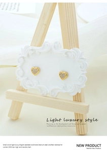 Detailed macro of gold titanium steel heart stud earrings with sparkling cubic zirconia pavé