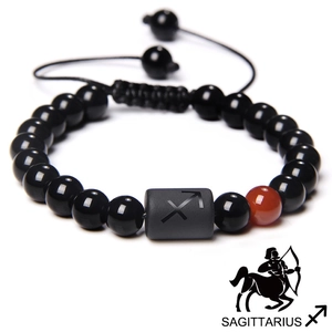 Macro shot of Sagittarius zodiac black bead bracelet with orange stone and woven cord