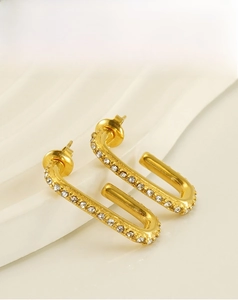 Detail of gold-plated U-shaped titanium steel earrings with zircon inlay craftsmanship