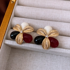 Detail of vintage tri-color floral earrings with resin petals and gold etched borders