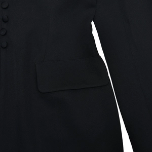 Close-up of black woven fabric texture with pocket flap and front button detail