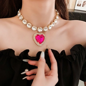 Close-up of sparkling heart necklace with pink rhinestone pendant on female model neck