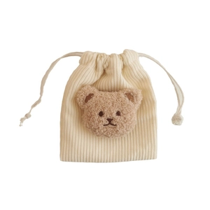 Cream corduroy drawstring pouch featuring a cute plush bear patch for storage