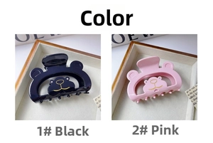 Detailed view of pink and black bear hair claws with gold-lined bear face and rhinestones