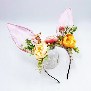 Dettaglio del cerchietto con orecchie di coniglio rosa e fiori artificiali colorati