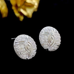 Macro view of silver oval stud earrings with pavé set white cubic zirconia crystals