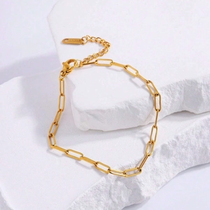 Elegant gold paperclip chain bracelet in stainless steel with lobster clasp on white stone