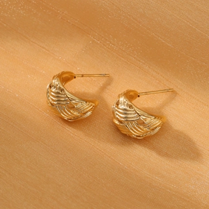 Macro shot of French vintage gold woven texture C-shape stainless steel earrings