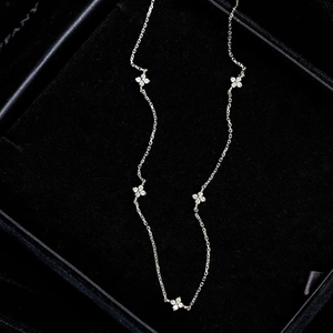 Elegant S925 sterling silver necklace with five sparkling clover charms on black velvet