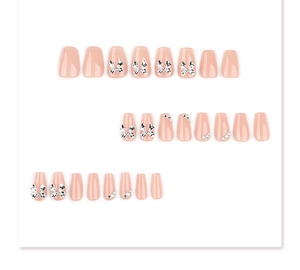 Detail showing pink coffin fake nails with silver bow charms and small rhinestones