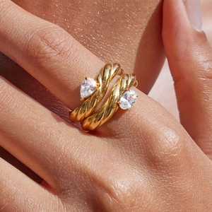 Elegant gold twisted titanium steel ring featuring two pear-cut crystal stones on hand