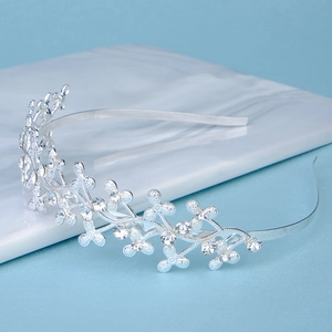 Detailed view of a silver tiara headband featuring sparkling crystals in floral patterns