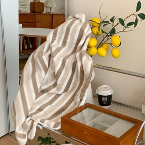 Thick striped bath towel with plush texture shown in a cozy home setting
