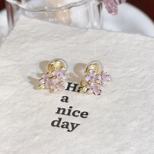 Detail of lavender enamel flower clip-on earrings with mosquito coil back design