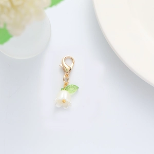 Close-up of lily of the valley pendant with translucent leaf and golden lobster clasp
