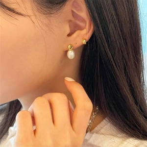Elegant S925 silver earring with white pearl and irregular golden ring on a model